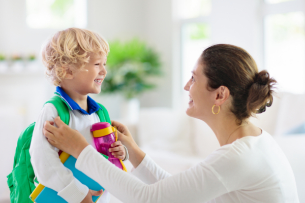 woman and smiling boy with backpack