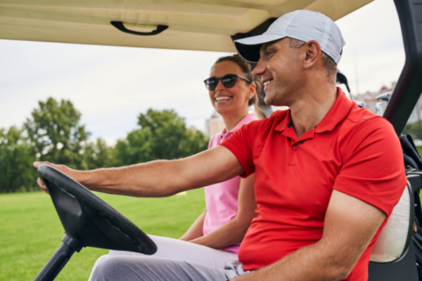 man and woman in golf cart