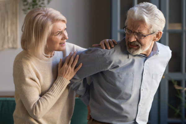 woman supporting man with back pain